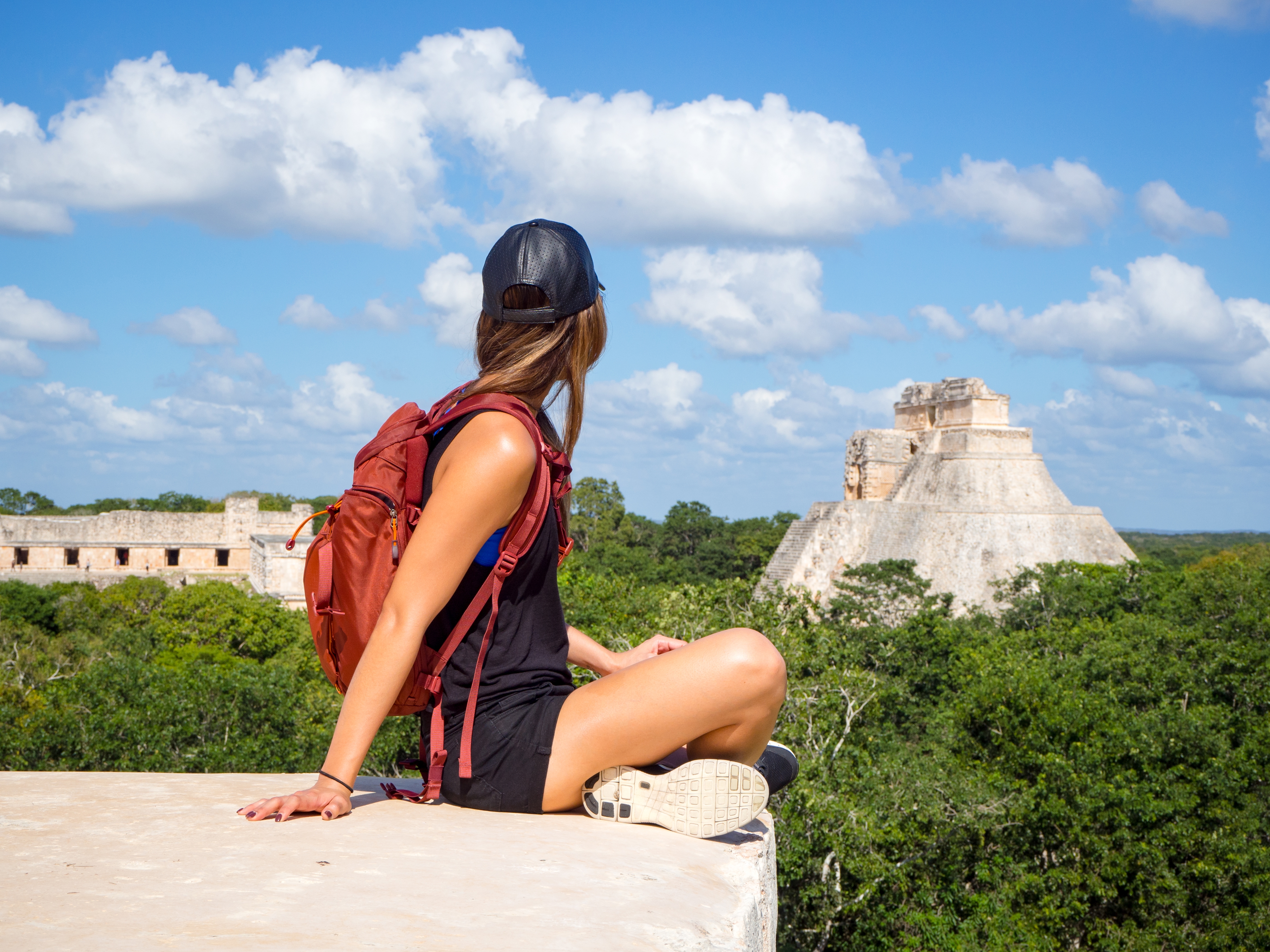 Young woman traveling with backpack in Mexico, exploring the Uxmal mayan ruins in the Yucatan